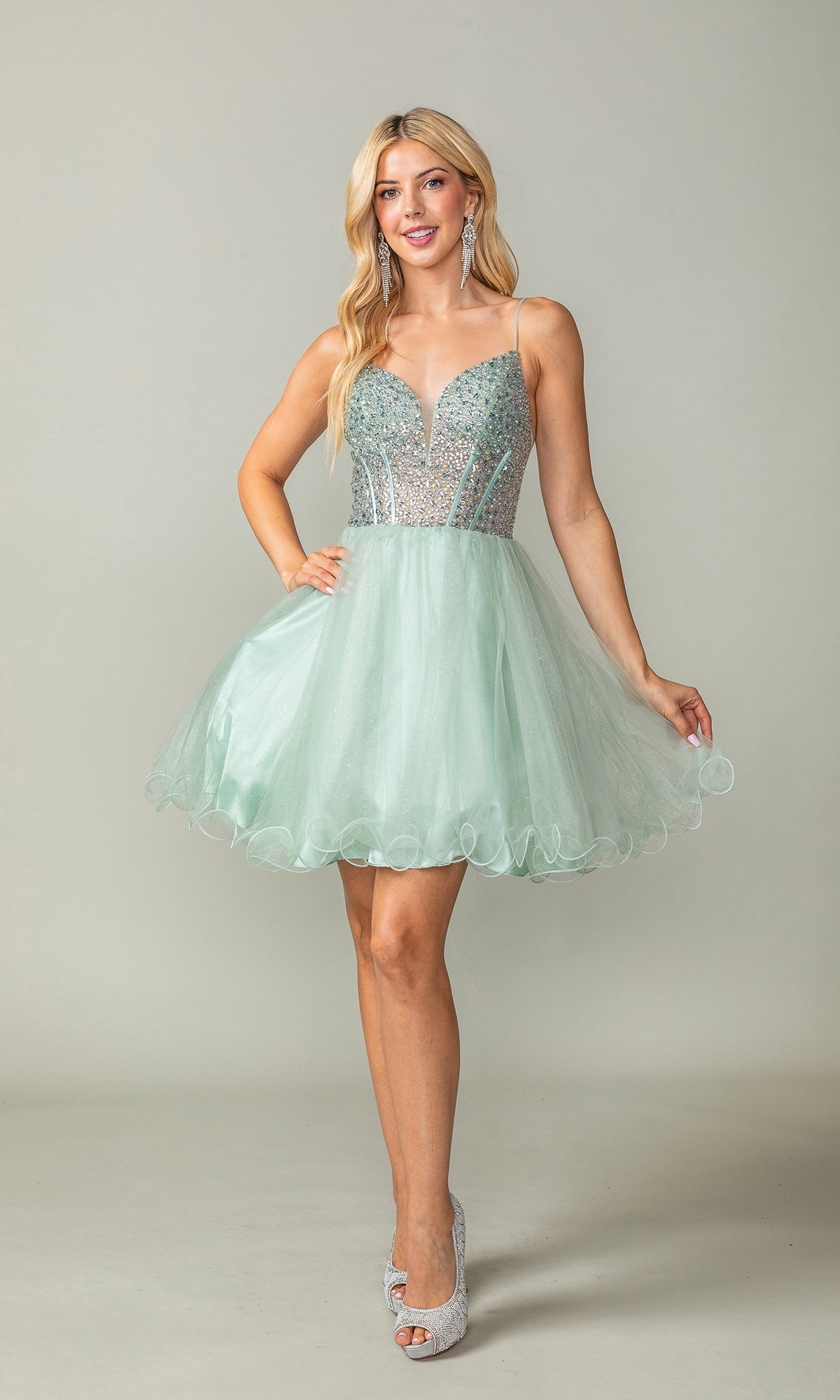 A woman poses against a plain background in the Beaded Corset Short A-Line Homecoming Dress 3353, a mint green babydoll style with a beaded corset bodice, short tulle skirt, and silver high heels.